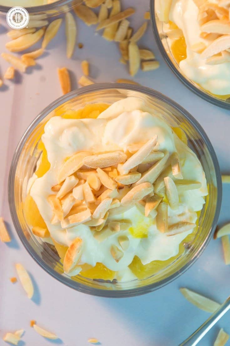 Our mango orange pineapple trifle is made of delicious layers of crushed granola, roasted almonds, fresh pineapple, mango sauce and creamy clotted cream. It tastes both luxurious and creamy, as well as fruity and airy! #dessert #recipe #trifle | countryhillcottage.com