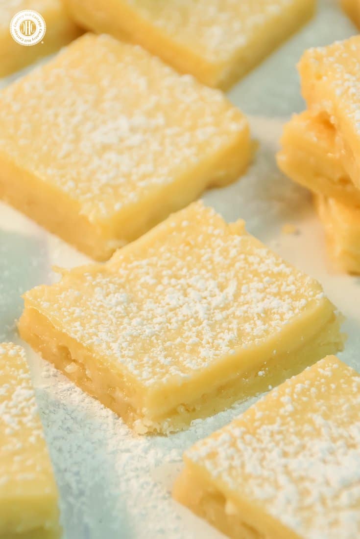 Layer a crumbly crust with a flavorful lemon topping to create creamy lemon squares! Dusted with icing sugar, these bars are perfect to serve with tea, or as a delicious present for all lemon lovers. You can find printable treat boxes to gift the lemon squares at our blog. #lemonsquares #baking #recipe | countryhillcottage.com Layer a crumbly crust with a flavorful lemon topping to create creamy lemon squares! Dusted with icing sugar, these bars are perfect to serve with tea, or as a delicious present for all lemon lovers. You can find printable treat boxes to gift the lemon squares at our blog. #lemonsquares #baking #recipe | countryhillcottage.com
