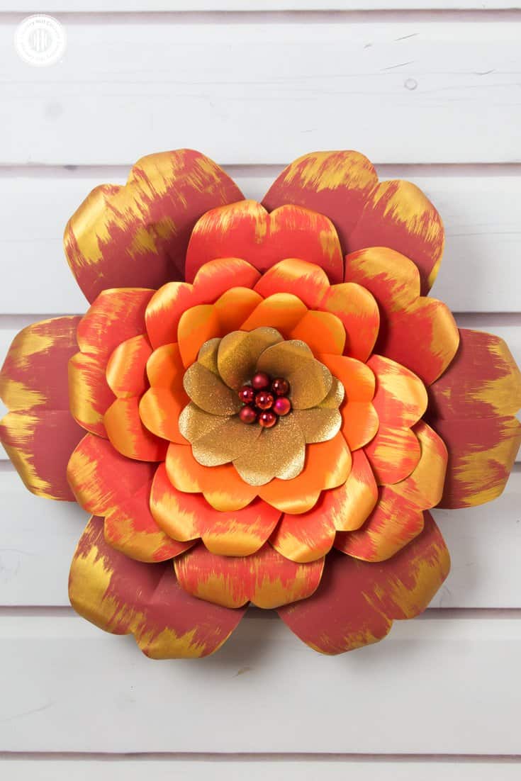 Learn how to make giant red and gold paper flowers! We worked with vibrant shades of cardstock for the petals, ranging from dark red to deep orange, as well as gold glitter paper, and embellished the edges of the petals with gold accents. We used mini bauble ornaments to create the flower centre and to give the flower an elegant finish. You can download the free printable templates we used to make the flowers at our blog. #paperflowers #template #papercrafts | countryhillcottage.com