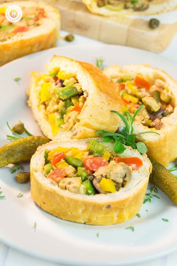 Ready for a new take on sandwiches? Then try Patafla, a delicious Mediterranean picnic loaf! Patafla is made with a French loaf (sounds scrumptious already, right?), and stuffed with a colourful summer veggie filling. Aside from being a terrific addition to your picnic basket, patafla also is a great party appetiser to feed a large crowd. #patafla #picnic #sandwich #recipe #tomatoes #peppers | countryhillcottage.com