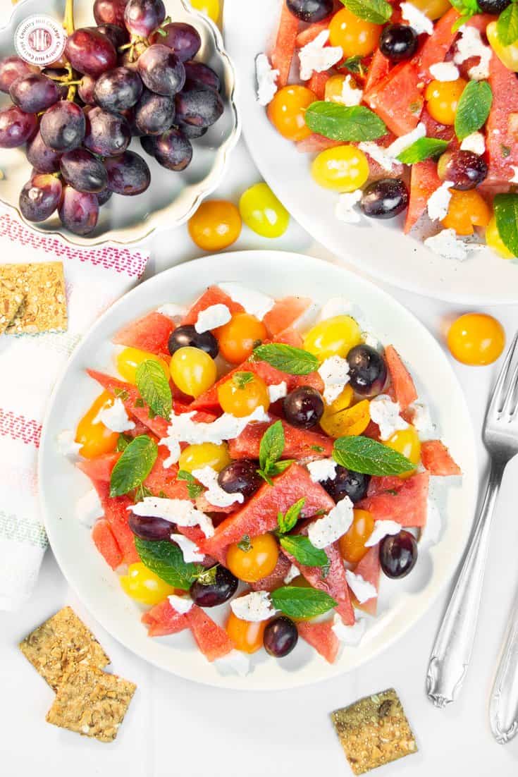 This quick and colourful watermelon salad is packed with fresh fruits and perfect to cool down on hot summer evenings. Aside from juicy watermelon slices, the recipe includes mozzarella cheese, cherry tomatoes and blue grapes, which add a burst of deep, rich sweetness. A lime vinaigrette with grapeseed oil adds zest to this light salad, while fresh mint leaves bring a fresh kick throughout. #watermelonsalad #watermelon #salad #grapes #mint #summersalad| countryhillcottage.com This quick and colourful watermelon salad is packed with fresh fruits and perfect to cool down on hot summer evenings. Aside from juicy watermelon slices, the recipe includes mozzarella cheese, cherry tomatoes and blue grapes, which add a burst of deep, rich sweetness. A lime vinaigrette with grapeseed oil adds zest to this light salad, while fresh mint leaves bring a fresh kick throughout. #watermelonsalad #watermelon #salad #grapes #mint #summersalad| countryhillcottage.com