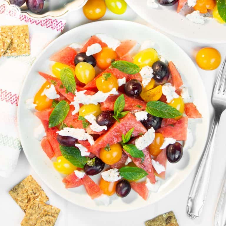 This quick and colourful watermelon salad is packed with fresh fruits and perfect to cool down on hot summer evenings. Aside from juicy watermelon slices, the recipe includes mozzarella cheese, cherry tomatoes and blue grapes, which add a burst of deep, rich sweetness. A lime vinaigrette with grapeseed oil adds zest to this light salad, while fresh mint leaves bring a fresh kick throughout. #watermelonsalad #watermelon #salad #grapes #mint #summersalad| countryhillcottage.com