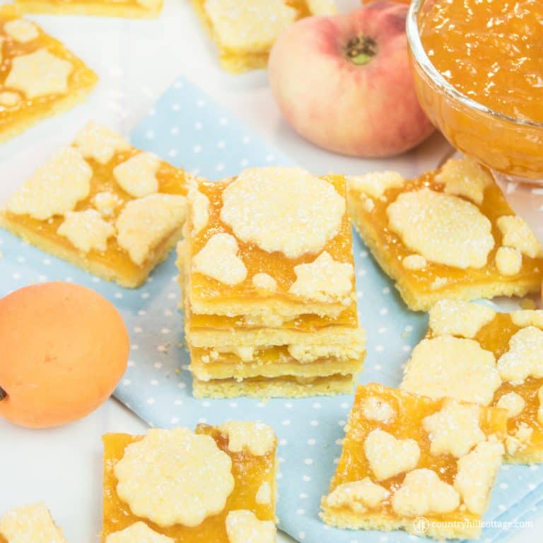 These decorative jam biscuits taste super scrumptious and look pretty to give as food gifts. The cookie dough is made with all-purpose flour and maize flour (yellow cornmeal), which gives the biscuits their sunny colour and adds a nice, gritty texture. We used peach jam but other apricot jam or raspberry preserve a tasty alternatives. These jam biscuits make wonderful little presents. #cookies #biscuits #cookierecipe #holidaybaking |countryhillcottage.com