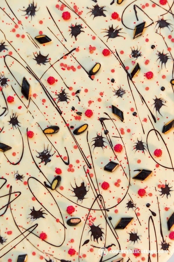 No spells are needed to make Creepy Crawler Chocolate Bark, which is a fun candy bark made with white and dark chocolate, sprinkles and liquorice. You don’t have to be a candy expert to make this treat. Just melt, pour, and decorate away. Easy. You can serve the candy bark for a Halloween party or package it in cellophane bags to gift and hand out to trick-or-treaters. #chocolatebark #candybark #chocolate #Halloween | countryhillcottage.com No spells are needed to make Creepy Crawler Chocolate Bark, which is a fun candy bark made with white and dark chocolate, sprinkles and liquorice. You don’t have to be a candy expert to make this treat. Just melt, pour, and decorate away. Easy. You can serve the candy bark for a Halloween party or package it in cellophane bags to gift and hand out to trick-or-treaters. #chocolatebark #candybark #chocolate #Halloween | countryhillcottage.com