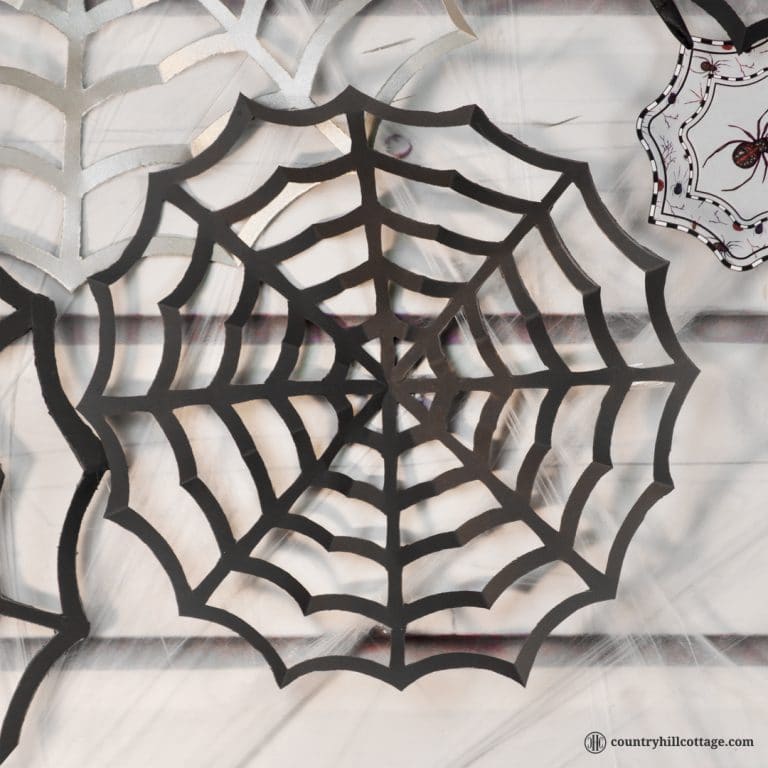 Paper spider webs add super spooky vibes to your home or classroom! DIY cobwebs look great as wall ornament, front door or window ornament, party décor and photo backdrop. All you need for this Halloween craft is paper, pencils, and craft scissors. This is a great DIY project to make with kids and an easy teacher Halloween craft for the classroom. Included are a free printable template and instructions. #DIY #spiderweb #Halloween #papercrafts | countryhillcottage.com