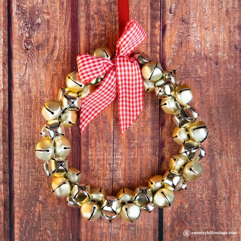 Show off your festive spirit and learn to make an easy and quick jingle bell wreath. This pretty DIY Christmas wreath adds festive touches to your front door, mantle or party décor! You only need a handful of bells, a piece of sturdy wire, ribbon and not more than five minutes to create this beautiful homemade craft holiday wreath. You can use the jingle bells wreath as Christmas door decoration or wall ornament. #wreath #ChristmasWreath #HolidayWreath #Christmas | countryhillcottage.com