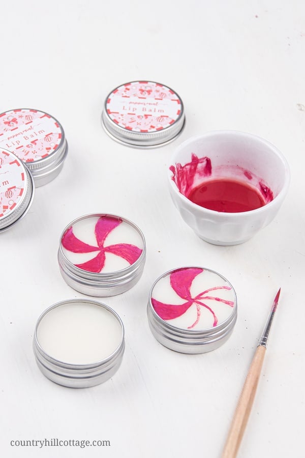 How to make the best peppermint lip balm! The easy natural DIY candy cane lip balm recipe is very moisturizing and perfect to soothe dry, cracked lips. The lip balm without beeswax is vegan and plant-based. The homemade peppermint chapstick is a cute Christmas gift and comes with free printable lip balm labels for packaging tube and containers. Made with shea butter and essential oils, great for kids. #lipbalm #peppermint #candycane #printable #essentialoils #holidays | countryhillcottage.com