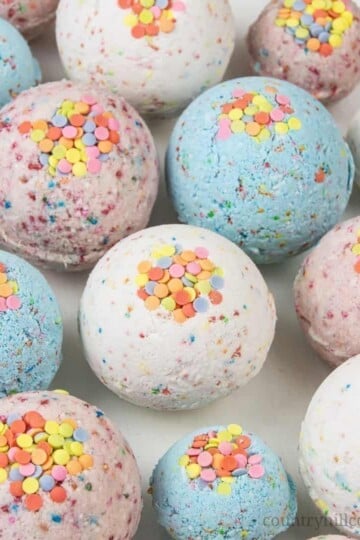 DIY bath bombs without citric acid or cream of tartar are an easy homemade bath bomb recipe for kids. These bath bombs turn a boring bath time routine into a fun experience for girls and boys. Learn how to make and customise these simple 3-ingredient funfetti bath fizzies with sprinkles, colour, and natural organic essential oils that are safe for children. Lush inspired, great gift idea. Without cornstarch, without Epsom salt, no citric acid. #bathbombs #essentialoils | countryhillcottage.com