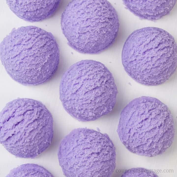 Learn how to make DIY lavender bubble bath bars scoops for a spa experience! Made with essential oils, citric acid, baking soda, moisturising cocoa butter, coconut oil and an ice cream scoop, these DIY bath truffles soften the skin, relaxes your senses and create long-lasting bubbles. This solid bubble bar recipe is easier to make than bath bombs and a great homemade gifts idea. Tutorial with step-by-step instructions. #bathtruffle #bathbomb #bubblebar #essentialoils | countryhillcottage.com