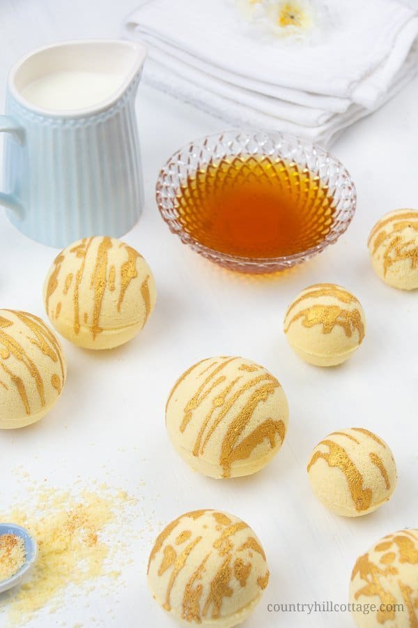 Enjoy a hydrating bath with these relaxing DIY moisturising bath bombs! The easy and natural bath bomb recipe, made with cocoa butter, milk powder, honey powder, and scented essential oils, will leave your skin supple and soft. Homemade milk and honey bath fizzies to improve skin health and improve the beauty of the skin. Learn how to make DIY bath bombs without cornstarch. #bathfizzy #milkbath #bathbomb #DIYbathbomb #DIYbeauty #DIYbath #lushbathbomb #essentialoils | CountryHillCottage.com
