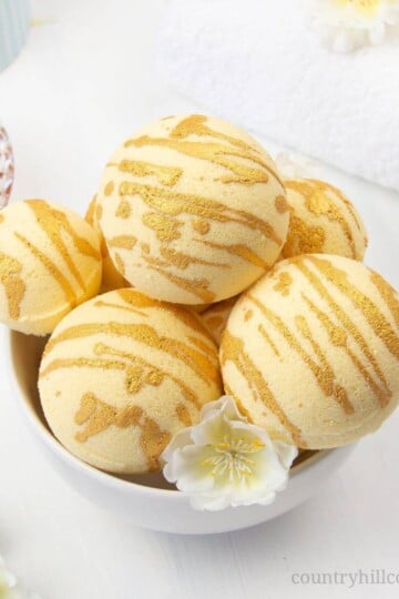 Enjoy a hydrating bath with these relaxing DIY moisturising bath bombs! The easy and natural bath bomb recipe, made with cocoa butter, milk powder, honey powder, and scented essential oils, will leave your skin supple and soft. Homemade milk and honey bath fizzies to improve skin health and improve the beauty of the skin. Learn how to make DIY bath bombs without cornstarch. #bathfizzy #milkbath #bathbomb #DIYbathbomb #DIYbeauty #DIYbath #lushbathbomb #essentialoils | CountryHillCottage.com