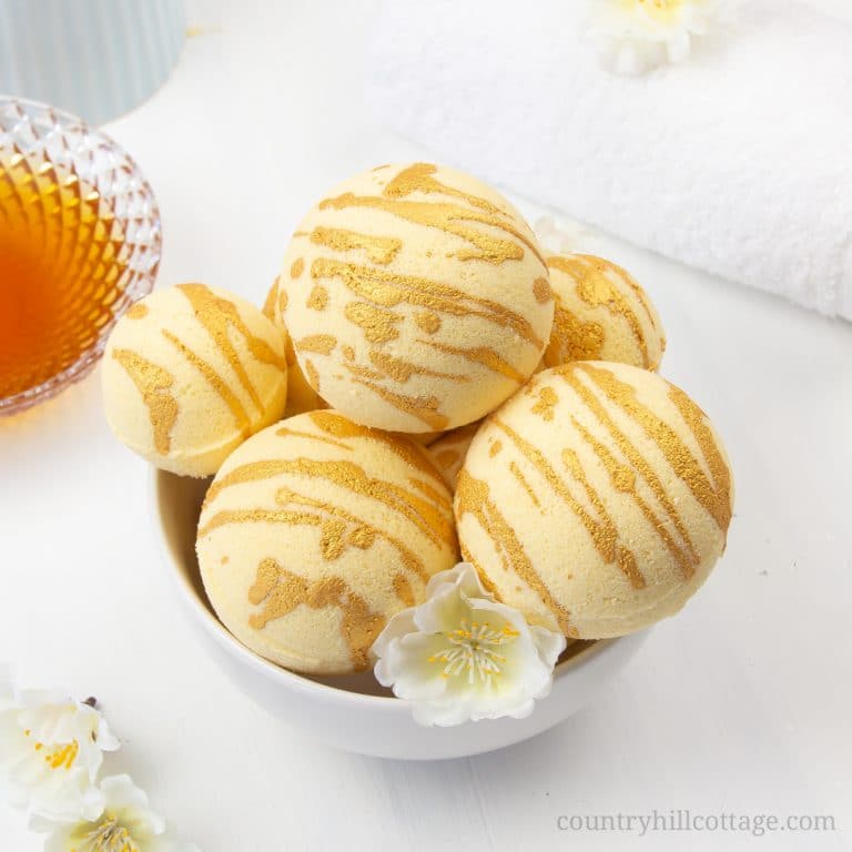 Enjoy a hydrating bath with these relaxing DIY moisturising bath bombs! The easy and natural bath bomb recipe, made with cocoa butter, milk powder, honey powder, and scented essential oils, will leave your skin supple and soft. Homemade milk and honey bath fizzies to improve skin health and improve the beauty of the skin. Learn how to make DIY bath bombs without cornstarch. #bathfizzy #milkbath #bathbomb #DIYbathbomb #DIYbeauty #DIYbath #lushbathbomb #essentialoils | CountryHillCottage.com