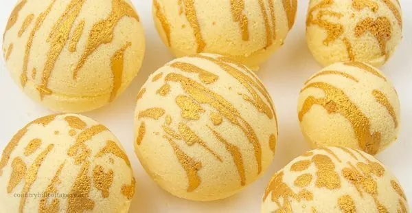 Enjoy a hydrating bath with these relaxing DIY moisturising bath bombs! The easy and natural bath bomb recipe, made with cocoa butter, milk powder, honey powder, and scented essential oils, will leave your skin supple and soft. Homemade milk and honey bath fizzies to improve skin health and improve the beauty of the skin. Learn how to make DIY bath bombs without cornstarch. #bathfizzy #milkbath #bathbomb #DIYbathbomb #DIYbeauty #DIYbath #lushbathbomb #essentialoils | CountryHillCottage.com
