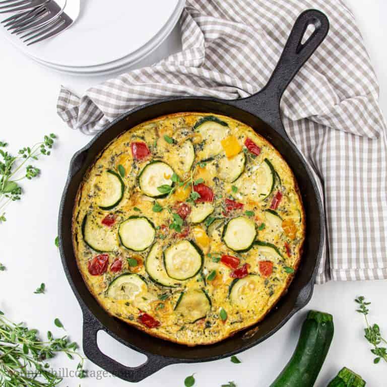 An easy one-pan zucchini frittata is a healthy vegetarian make ahead meal idea for breakfast, brunch, and midweek dinners that your family will love. Prepared in an iron cast skillet, this simple and healthy no cheese veggie frittata recipe is low carb, gluten-free, dairy-free, paleo, Keto and Whole 30 friendly. A tasty zucchini recipe perfect for clean eating! #frittata #zucchini #keto #paleo #glutenfree #cleaneating #vegetarian #whole30 #breakfast #dairyfree #lowcarb | countryhillcottage.com