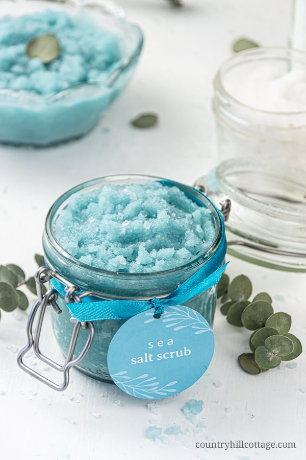 How to make easy homemade sea salt scrub for glowing skin, hands, body, foot! The best natural exfoliating DIY salt scrub recipe is made with organic moisturizing coconut oil and lemon lime essential oils has many skin care benefits and can be made with Epsom, pink Himalayan or dead sea salt. With tips for vs sugar scrub, how to store and use body scrub, packaging ideas and printable labels. Make your own Lush Ocean Salts beauty products at home. #bodyscrub #saltscrub | countryhillcottage.com