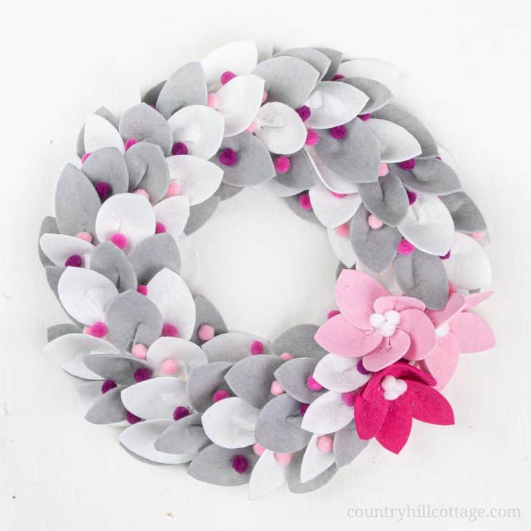 See how to make a festive DIY Christmas felt wreath! Creating your own homemade Christmas wreath with felt is super easy and fun. The simple tutorial includes modern winter farmhouse white grey and traditional red green holiday wreath ideas to fit any style of home decor. This handmade holiday felt craft comes with free printable pattern templates and SVG files for Cricut. Make sizes mini, small or large. #Christmaswreath #holidaywreath #feltwreath #felt #christmascraft | countryhillcottage.com