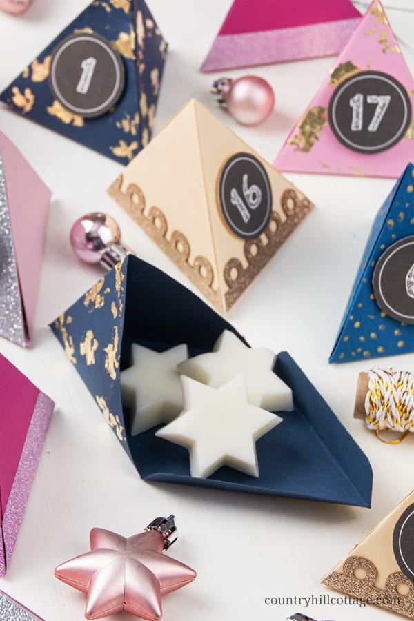 Make your own easy DIY paper advent calendar with free printable templates for the boxes numbers! This homemade advent calendar is a fun Christmas papercraft and holiday gift for kids, adults, husband, boyfriend, teens, children. The tutorial includes handmade advent calendar fillers ideas like chocolate and beauty items for what to put in. The design cane me modern or traditional and comes with PDF and SVG templates. #adventcalendar #papercrafts #DIY #holidaycrafts | countryhillcottage.com