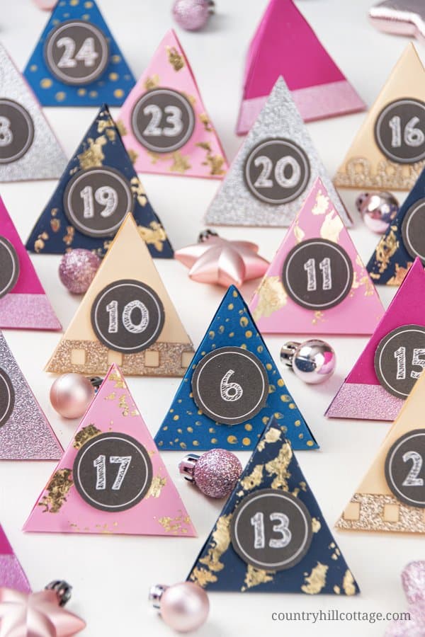 Make your own easy DIY paper advent calendar with free printable templates for the boxes numbers! This homemade advent calendar is a fun Christmas papercraft and holiday gift for kids, adults, husband, boyfriend, teens, children. The tutorial includes handmade advent calendar fillers ideas like chocolate and beauty items for what to put in. The design cane me modern or traditional and comes with PDF and SVG templates. #adventcalendar #papercrafts #DIY #holidaycrafts | countryhillcottage.com