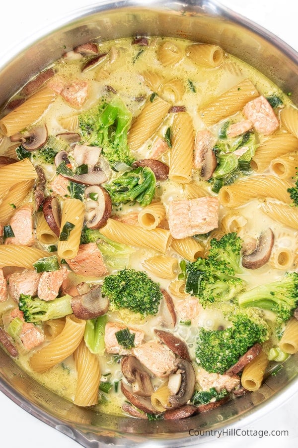 Dairy free one pot pasta with salmon cooking in a pot