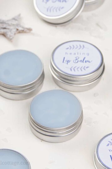 See how to make a simple healing lip balm recipe to care for chapped, peeling lips! This homemade natural lip balm for dry lips with organic coconut oil, hydrating castor oil and hemp seed oil is ready in minutes. This easy DIY lip balm without beeswax is a great moisturizing lip balm for winter and tinted with shimmer mica. The step-by-step tutorial includes cute labels for packaging containers. #skincare #vegan #lipbalm #beautydiy #essentialoils #coconutoil #winter | countryhillcottage.com