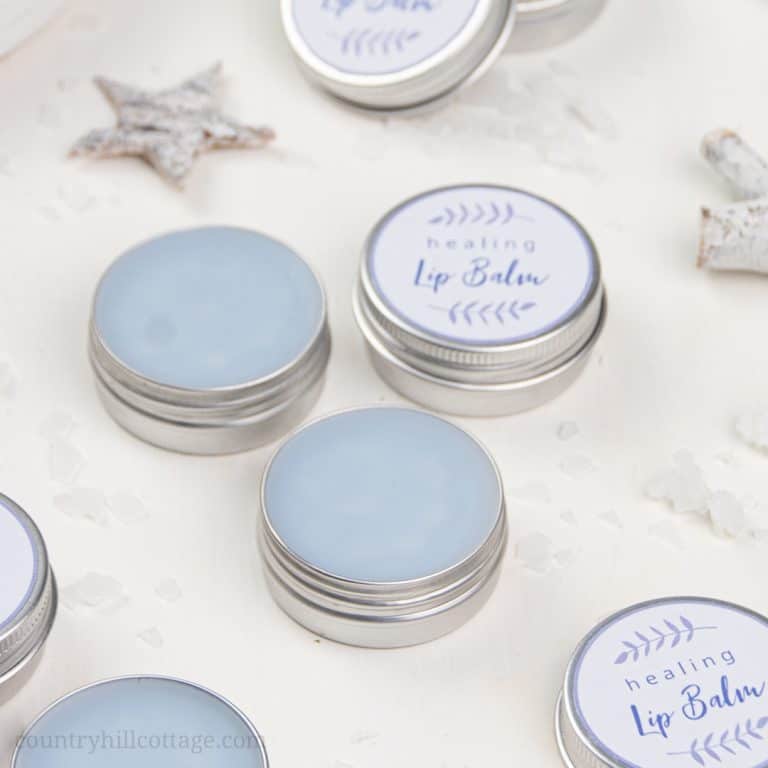 See how to make a simple healing lip balm recipe to care for chapped, peeling lips! This homemade natural lip balm for dry lips with organic coconut oil, hydrating castor oil and hemp seed oil is ready in minutes. This easy DIY lip balm without beeswax is a great moisturizing lip balm for winter and tinted with shimmer mica. The step-by-step tutorial includes cute labels for packaging containers. #skincare #vegan #lipbalm #beautydiy #essentialoils #coconutoil #winter | countryhillcottage.com
