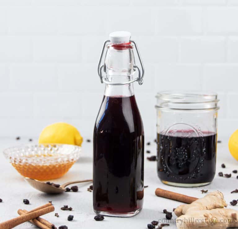 See how to make homemade thick elderberry syrup with dried elderberry. The DIY recipe can be made with turmeric, echinacea, rosehips, apple cider, essential oils, vegan without honey, in the Instant Pot, crockpot, pressure cooker or slow cooker. The syrup is great for colds, babies, kids and toddlers and has health benefits for the immune system. With tips for canning, uses, how to take, dosage chart and printable labels. #elderberries #elderberrysyrup #naturalremedy | countryhillcottage.com