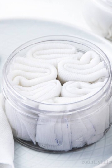 How to make easy DIY hand sanitizer wipes! The homemade antibacterial wipes recipe is made with natural organic ingredients (vodka, aloe vera, essential oils) and reusable wipes. Use the portable mini disinfectant hand wipes with alcohol for travel or when hand washing isn’t possible. Cute gift or baby shower favor. Disinfecting wipes are good for kids and classroom uses. With printable labels for the dispenser and packaging the container. #handsanitizer #essentialoils | countryhillcottage.com