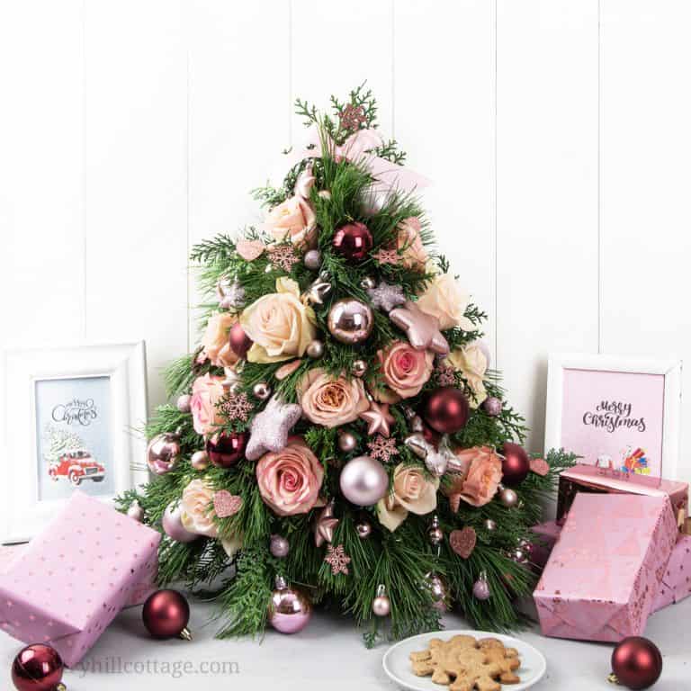 See how to make a Christmas tree centerpiece with pretty ornaments, real pine and fresh flowers! A mini DIY tabletop Christmas tree is an excellent holiday decoration for small spaces and a beautiful Christmas arrangement for a table, the kitchen, bedroom, living or dinning room. You learn display ideas and small Christmas tree decorating ideas for modern, vintage, rustic and Farmhouse. #TabletopChristmasTree #centerpiece #ChristmasTree #Christmasdecor #minitree | countryhillcottage.com