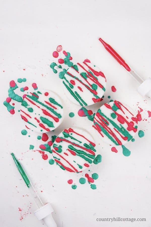 See how to make and decorate homemade candy cane bath bombs with mica paint. This easy Christmas bath bomb recipe looks and smells very festive and is an excellent handmade bath gift idea for the holiday season. Great for kids. With storage tips, packaging ideas and printable gift tags. #peppermint #bathbombs #inwater #essentialoils | countryhillcottage.com
