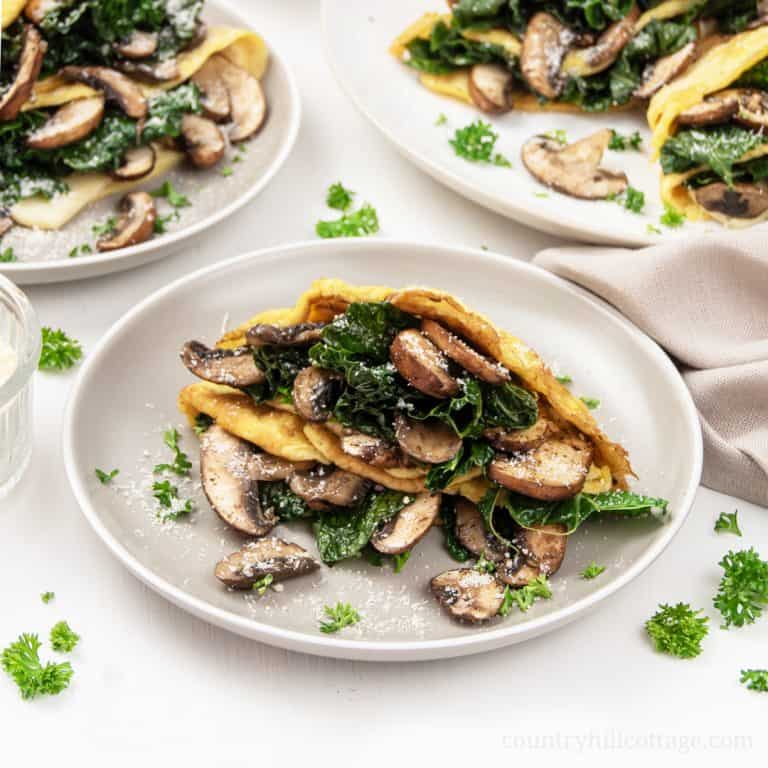 Easy mushroom kale frittata crepes are a thinly cooked frittata transformed into a posh crepes-look-alike filled with tender kale and wild mushrooms. The Italian meal idea make a quick midweek dinner or lunch and can be served as a side, appetizer or a main. Ready in 20 minutes, this easy healthy frittata recipe is vegetarian, gluten-free, low-carb, keto and clean eating friendly. #frittata #kale #midweek #dinner #keto #glutenfree #cleaneating #vegetarian #lowcarb | countryhillcottage.com