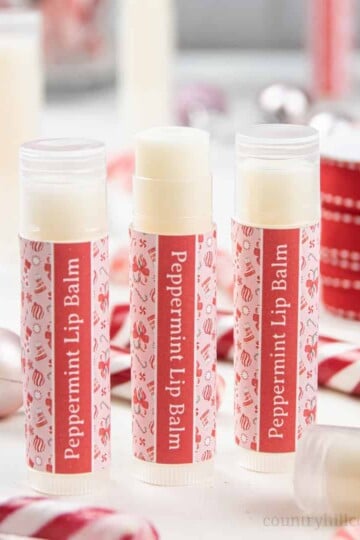How to make the best peppermint lip balm! The easy natural DIY candy cane lip balm recipe is very moisturizing and perfect to soothe dry, cracked lips. The lip balm without beeswax is vegan and plant-based. The homemade peppermint chapstick is a cute Christmas gift and comes with free printable lip balm labels for packaging tube and containers. Made with shea butter and essential oils, great for kids. #lipbalm #peppermint #candycane #printable #essentialoils #holidays | countryhillcottage.com