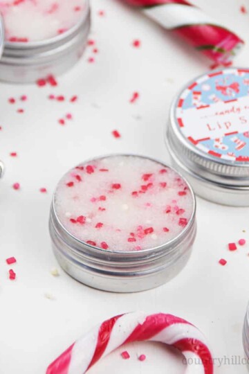 How to make the best vegan DIY peppermint sugar scrub with sugar, coconut oil, essential oils and organic ingredients. Homemade candy cane lip scrub recipe is easy a cute homemade Christmas gift. This simple edible natural pink mint sugar scrub without honey for dead skin includes free printable labels for packaging containers. Good benefits for exfoliating, plumping, moisturizing. Also learn how to use and how to apply. #lipscrub #sugrascrub #DIYscrub #homemadescrub | countryhillcottage.com