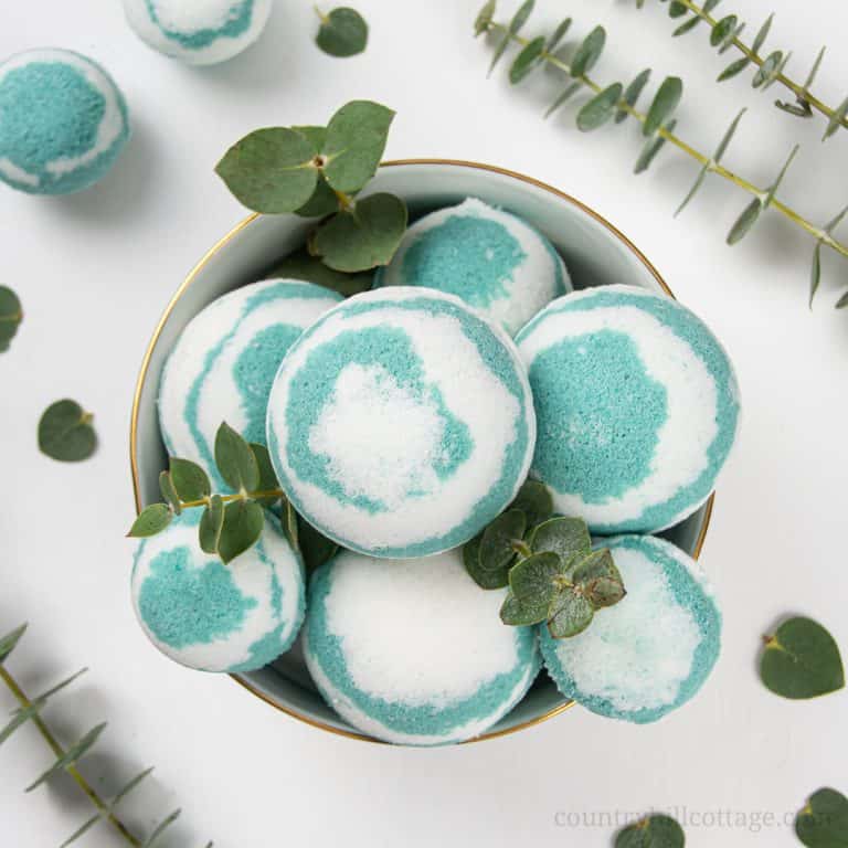 This easy homemade eucalyptus bath bombs recipe looks pretty in water and is very relaxing, perfect for at home wellness! Pretty fizzy essential oil bath bombs without cornstarch are beneficial to relieve respiratory problems, sinus congestion and headaches, and to soothe sore muscles and joints. See how to make simple natural aromatherapy bath bombs with eucalyptus, learn about packaging and storage tips and other essential oil scents ideas like lavender, lemon or peppermint. Great for kids and men. #bathbombs #eucalyptus #aromatherapy #essentialoils | countryhillcottage.com