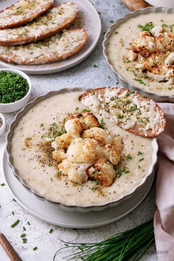 bowl of cauliflower soup without cream and cheese sandwich.